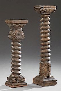 Two French Carved Oak Wine Press Screws, 19th c., now as pedestals, with grape and leaf carving, on sloping bases, Taller- H.