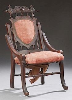 American Eastlake Hunzinger Style Carved Mahogany Folding Chair, late 19th c., the spindled finialed crest over a shield form