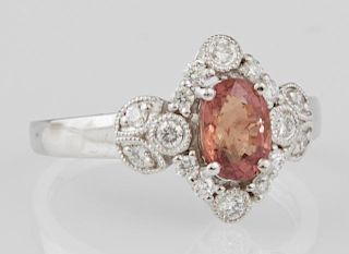 Lady's Platinum Dinner Ring, with an oval 1.23 carat natural orange sapphire atop a border of round diamonds flanked by diamo