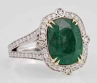 Lady's Platinum Dinner Ring, with a cushion cut 6.71 carat emerald within a conforming border of round diamonds, the split si
