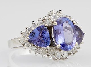 Lady's 14K White Gold Dinner Ring, with a large central oval tanzanite flanked by two trillion cut tanzanites, atop a conform