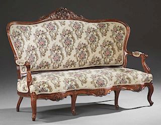 American Carved Walnut Sofa, 19th c., the arched curved upholstery back with a floral and leaf crest to upholstered arms, ove