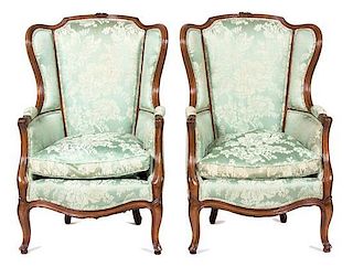 A Pair of Louis XV Style Carved Mahogany Wing Back Armchairs Height 44 inches.