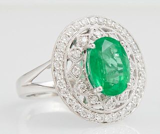 Lady's Platinum Dinner Ring, with an oval 3.6 carat emerald atop a pierced border of round diamonds, within an outer border o
