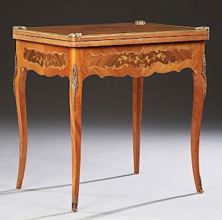 French Marquetry Inlaid Mahogany Louis XV Style Games Table, c. 1930, the brass bound swiveling inlaid top with a gilt tooled