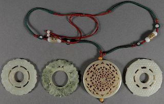 FOUR GOOD CHINESE CARVED JADE DISC FORM PENDANTS