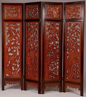 A LARGE HEAVILY CARVED CHINESE FOLDING SCREEN