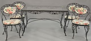 Five piece wrought iron glass top table and four chairs with cushions. ht. 29 in., top: 31" x 51"