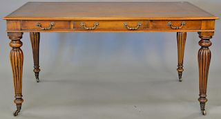 Contemporary leather top writing table with three drawers. ht. 30 in., top: 34" x 60"