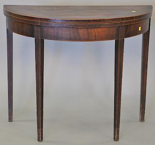 George III mahogany demilune game table with line inlays and felt interior (top with cracks). 
height 29 1/2 inches, width 36