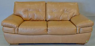Three piece Natuzzi leather loveseat, chair, and ottoman, light brown with white stitching. loveseat: lg. 76 in.
