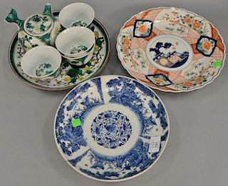 Japanese porcelain group to include famille verte tea set with teapot, four cups, and a charger; a blue and white charger (di