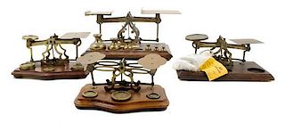 * A Group of Four Brass Postal Scales and Weights Width of largest 11 inches.
