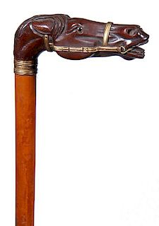 55. Thoroughbred Horse Cane- Ca. 1880- A carved horse head with two color glass eyes, gold-filled bridles and collar, malacc