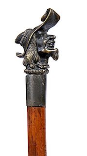9. Bronze Defensive Cane- Ca. 1870- A bronze 3-dimensional handle of a man with hat and beard which doubles as a knobkerrie,