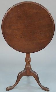 Federal walnut tip table having round top on turned shaft with twist carved urn, all set on tripod base. height 26 1/4 inche
