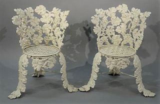 Two Victorian iron outdoor side chairs having grape and vine motif and pierced seats