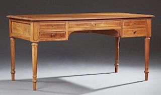French Louis XVI Style Carved Walnut Desk, late 19th c., the stepped rectangular top over a center drawer flanked by two draw