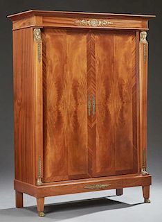 French Empire Style Ormolu Mounted Cherry Armoire, 20th c., the stepped crown over double doors flanked by tapered pilasters 