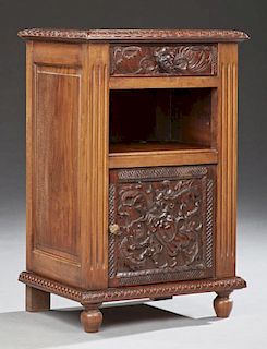 French Provincial Renaissance Carved Mahogany Nightstand, c. 1880, the sloped edge over a frieze drawer above an open shelf o