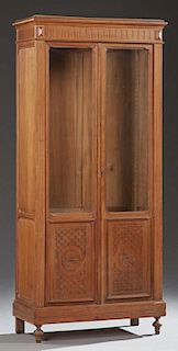 French Louis XVI Style Carved Cherry Bookcase, 19th c., the stepped top above double doors with glazed upper panels and geome