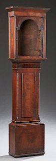 Georgian Carved Mahogany Clockcase, early 19th c., the stepped slanted crown over an arched door above a pendulum door, on a 