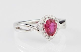 Lady's Platinum Dinner Ring, with a 1.04 ct pear shaped ruby atop a conforming border of small round diamonds, on a split pie