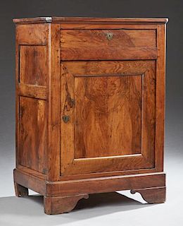 French Louis Philippe Style Carved Walnut Confiturier, c. 1850, the canted corner top over a frieze drawer and a large cupboa