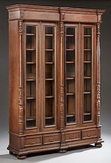 French Henri II Style Carved Oak Bookcase, c. 1880, the ogee stepped break front crown over two sections, each with two setba