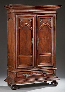 French Louis XIV Style Carved Walnut Armoire, 18th c., the stepped ogee crown over double two panel doors with applied fleur-