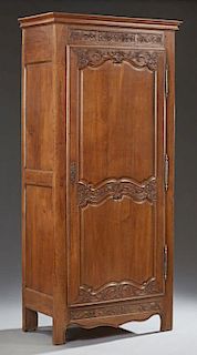 French Louis XV Style Carved Oak Bonnetiere, early 19th c., the stepped crown over a large double panel door with three iron 