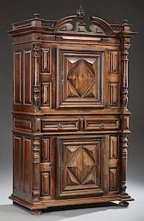 French Louis XIII Style Carved Walnut Homme Debout, 19th c., the broken arch breakfront stepped crown with a central urn fini