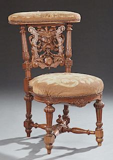 French Carved Oak Prie Dieu, 19th c., the upholstered arm rest over a mask and scroll carved backsplat, flanked by reeded tur
