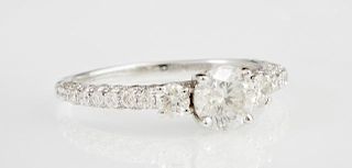 Lady's 18K White Gold Dinner Ring, with a .75 carat round diamond flanked by two round diamonds and diamond mounted shoulders