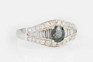 Lady's 18K White Gold Dinner Ring, with an oval green .94 carat sapphire flanked by a central row of graduated baguette diamo