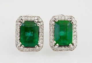 Pair of Platinum Stud Earrings, each with a 1.67 carat emerald atop an octagonal border of small round diamonds, total emeral