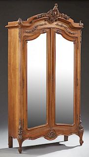 French Louis XV Style Carved Walnut Armoire, early 20th c., with an arched ogee crown with a large C-scroll and shell crest o