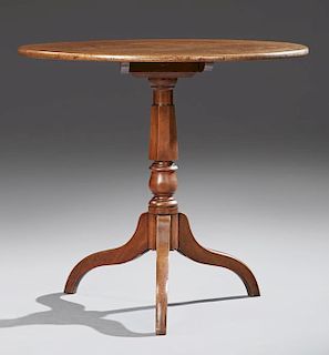 English Carved Mahogany Tilt Top Table, 19th c., the rounded edge circular top on a tapered turned support, on tripodal splay