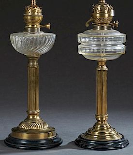 Two French Brass and Glass Oil Lamps, 19th c., the pressed glass fonts with original regulators, on reeded columnar supports 