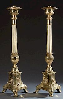 Pair of Large Brass Altar Candlesticks, 20th c., on reeded knopped supports, to triangular sloping bases with relief decorati