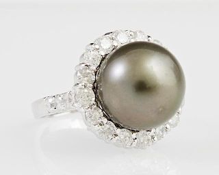 Lady's 14K White Gold Dinner Ring, with a 12.5 mm black Tahitian pearl atop a border of round diamonds, the shoulders of the 