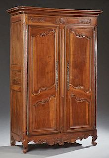 French Louis XV Style Carved Walnut Armoire, early 19th c., the stepped rounded edge ogee crown over double cupboard doors wi