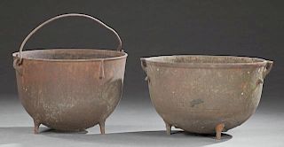 Two Cast Iron Sugar Kettles, 19th c., Louisiana, one with a folding iron handle, the second with ring handles, both on tripod