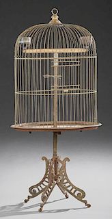 Large Oval Brass and Iron Birdcage, late 19th c., the rounded top cage on a removable iron base, on a cast iron support to fo