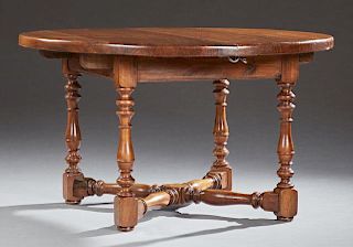 French Louis Philippe Style Carved Walnut Dining Table, 20th c., the thick circular top over a wide skirt on turned tapered a