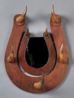 Carved Mahogany Hall Rack, c. 1900, of horseshoe form, with five cowhorn hat holders around a central horseshoe shaped mirror
