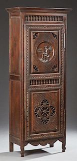 French Carved Oak Bonnetiere, 19th c., Brittany, the stepped crown above a spindled gallery over a long door, the top panel w