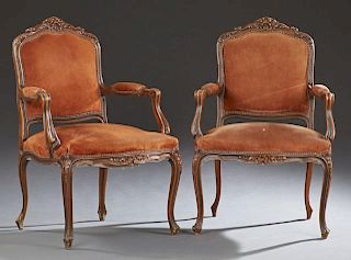 Pair of French Louis XV Style Carved Beech Fauteuils, early 20th c., the scrolled crest rail over an upholstered back and scr