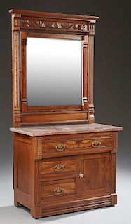 American Aesthetic Carved Walnut Marble Top Washstand, c. 1880, with a stepped ogee crown over a wide beveled swivel mirror, 