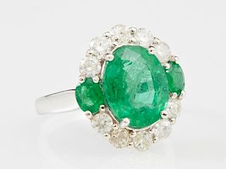 Lady's 14K White Gold Dinner Ring, with an oval 4.16 carat emerald, flanked on two sides by round emeralds, the top and botto